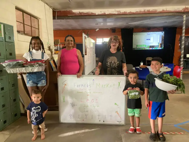 family with farmers market sign
